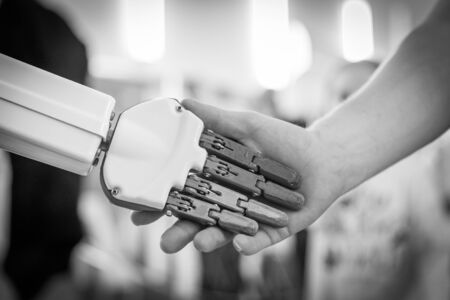 close up of man shaking hands with a robotの写真素材