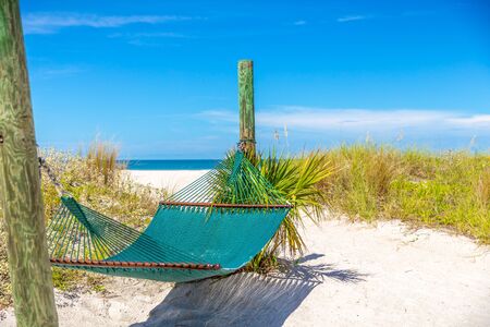 Relax with empty hammock and ocean background on tropical beach, vacation concept with copy spaceの写真素材