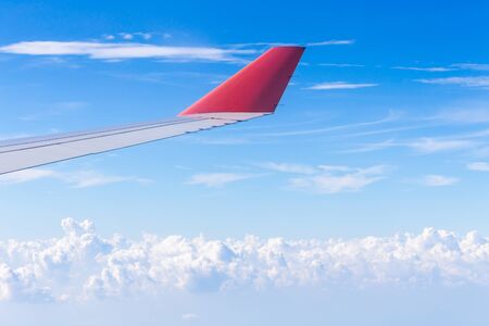 Wing of an airplane flying above the clouds