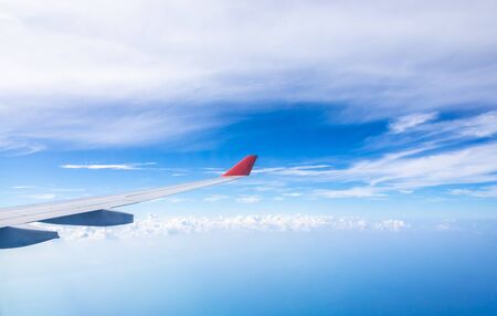 Wing of an airplane flying above the clouds
