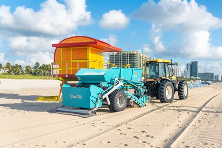 Miami, USA - September 11, 2019: Tractor cleaning sand in South beach in Miami