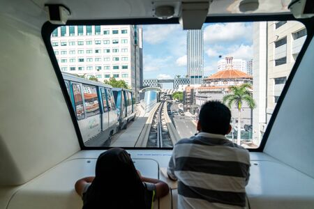 MIAMI - September 10, 2019: The fully automated Miami downtown train system with the city in the background. Father and son, view from inside of trainのeditorial素材