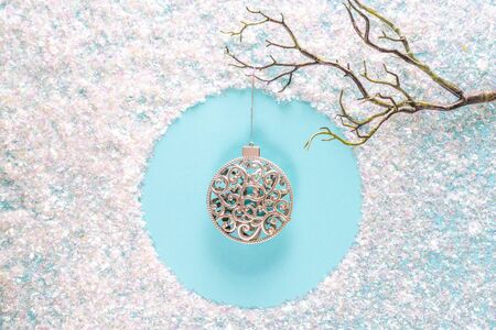 Modern Christmas holiday ornament decorations with sparkling tinsel on blue background.