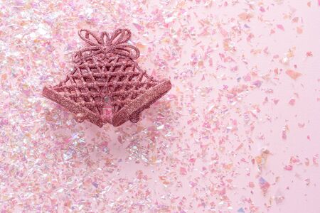 Vintage Jingle bell on pink glitter background. Minimal Christmas concept. Happy New Year. Flat lay, top view, copy spaceの写真素材