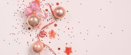 Panorama of Christmas composition. Christmas balls, pink and golden decorations on pink background....