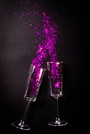 Two Glasses with violet tinsel on black background, flat lay top viewの写真素材