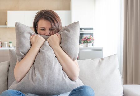 Sad depressed woman crying at pillow, loneliness and sadness conceptの写真素材