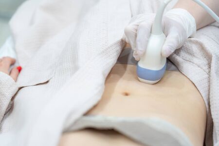 Young woman undergoing ultrasound scan in modern clinicの写真素材