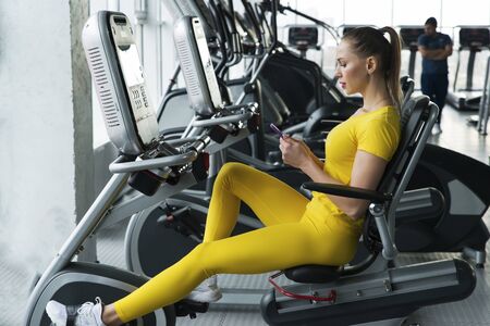Woman riding horizontal exercise bike in gym