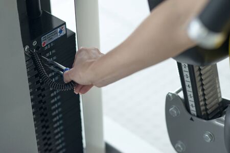 Weight adjustment on an training equipment at a gym. Separating weight for adjusting to size and...