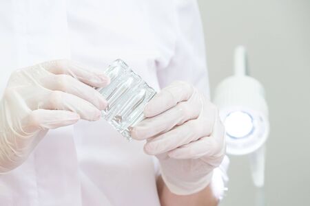 Doctor wearing medical gloves holding a pack of rectal or vaginal suppositories