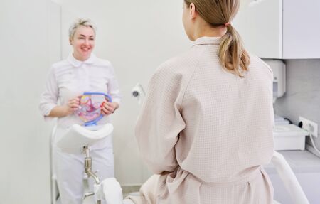 Gynecologist doctor consulting patient using uterus anatomy modelの写真素材