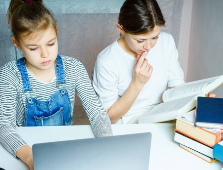Mother and daughter doing homework for school together, education concept