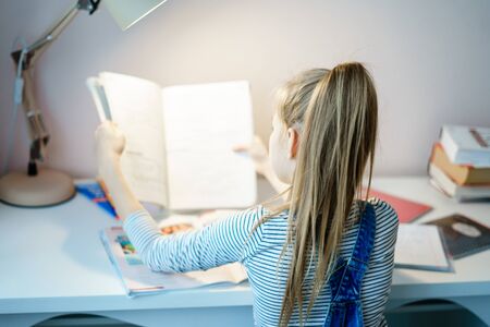 Teenage girl doing homework at table at home preparing for school test