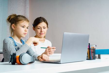 Mother and daughter doing homework for school together, education concept
