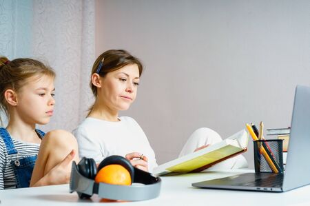 Mother and daughter doing homework for school together, education concept