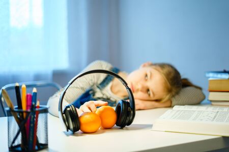 Student teenage girl lying on desk with books. young tired woman napping on her textbook. Tiredness,...