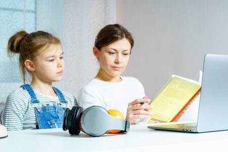 Mother and daughter doing homework for school together, education concept