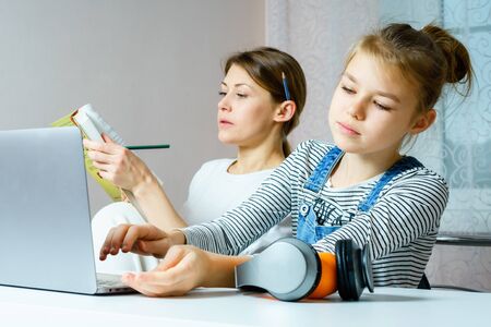 Mother and daughter doing homework together, styding and learning concept, doing tasks for schoolの写真素材