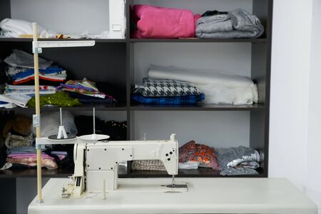 Sewing machine on table in workshop, tailor atelier