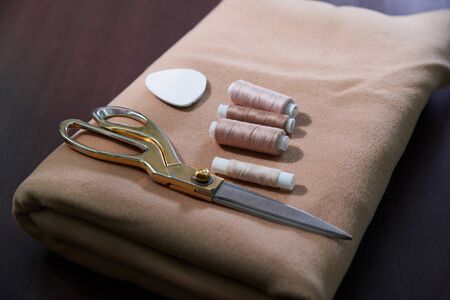 Group of sewing objects lying flat on a wooden table, concept of tailor shop
