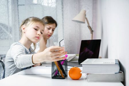 Mother and daughter doing homework together, styding and learning concept, doing tasks for school