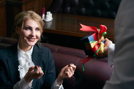 Man giving present box to a woman in restaurant