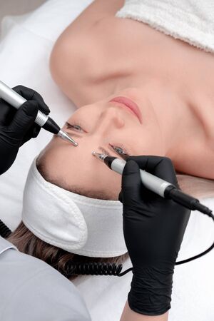 Cosmetology. Beautiful Woman At Spa Clinic Receiving Stimulating Electric Facial Treatment From...