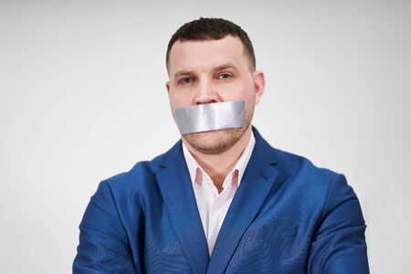 man has a big piece of black industrial tape covering his mouth, silence conceptの写真素材