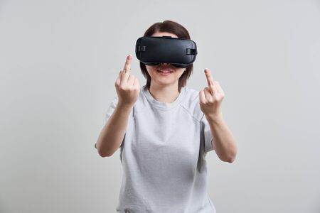 Happy young woman playing on VR glasses indoor, Virtual reality concept with young girl having fun with headset goggles, with copy spaceの写真素材
