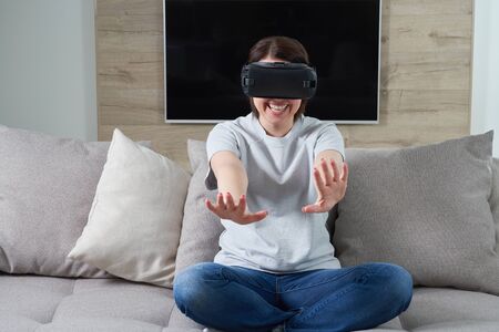 Happy young woman playing on VR glasses indoor, Virtual reality concept with young girl having fun...
