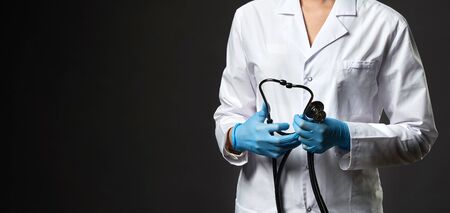 Young doctor with stethoscope against light background,の写真素材