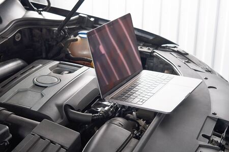 Laptop on a car in auto repair shop, Automobile mechanic repairman concept