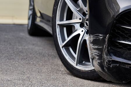 Black bumper car scratched with deep damage to the paint.の写真素材