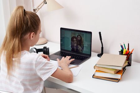 Teenage girl talking with her family on internet using video chat