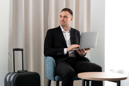 Young businessman using laptop while sitting in the business lounge in airport