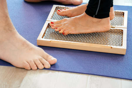 closeup of yoga person standing on sadhu board with sharp nails