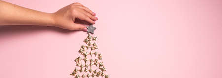 Hands decorating golden Christmas tree. View from above. Flat layの写真素材