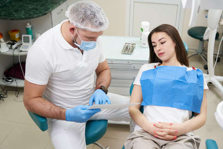 Doctor shows the patient an x-ray image. Computer diagnostics. dental tomographyの写真素材