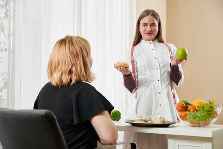 Young girl visiting nutritionist to lose weight with the help of diet programの写真素材