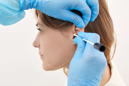 Ear check with cotton bud in medical laboratory