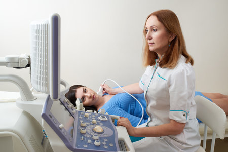 Doctor using ultrasound scanning machine examining female neckの写真素材