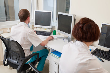 Male Doctor Working On Computer in medical clinicの写真素材