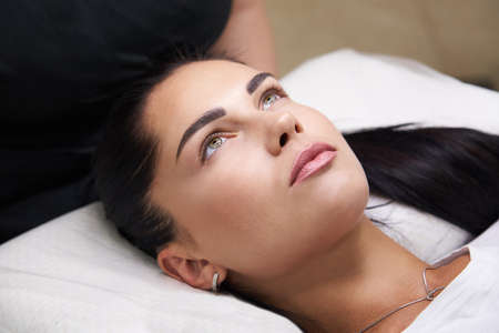 Beautiful woman laying at cosmetologist in spa salonの写真素材