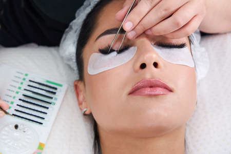 Eyelash Extension Procedure. Woman Eye with Long Eyelashes