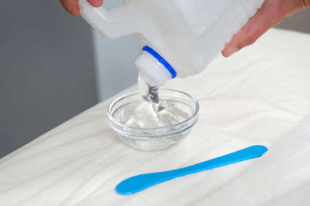 cosmetologist pooring transparent gel from a big bottleの写真素材