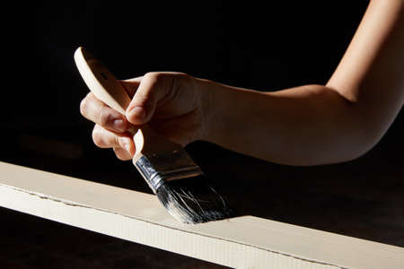Hand painting surface of natural wood plank into a white color on black backgroundの写真素材