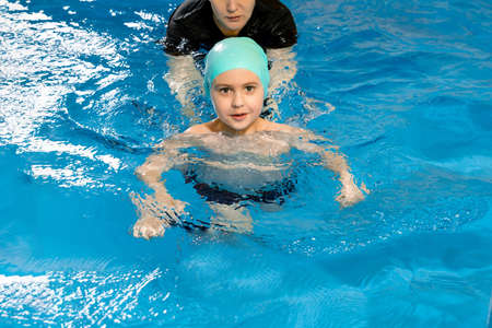 Mother teaches Child To Swim In indoor Poolの写真素材