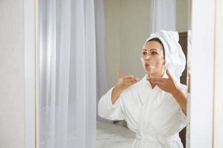 Young woman doing facial gymnastics self massage and rejuvenating exercises. Face building for skin and muscles liftingの写真素材