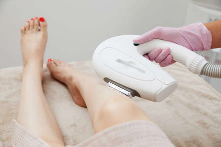 Partial view of woman receiving laser hair removal epilation on leg in a salonの写真素材